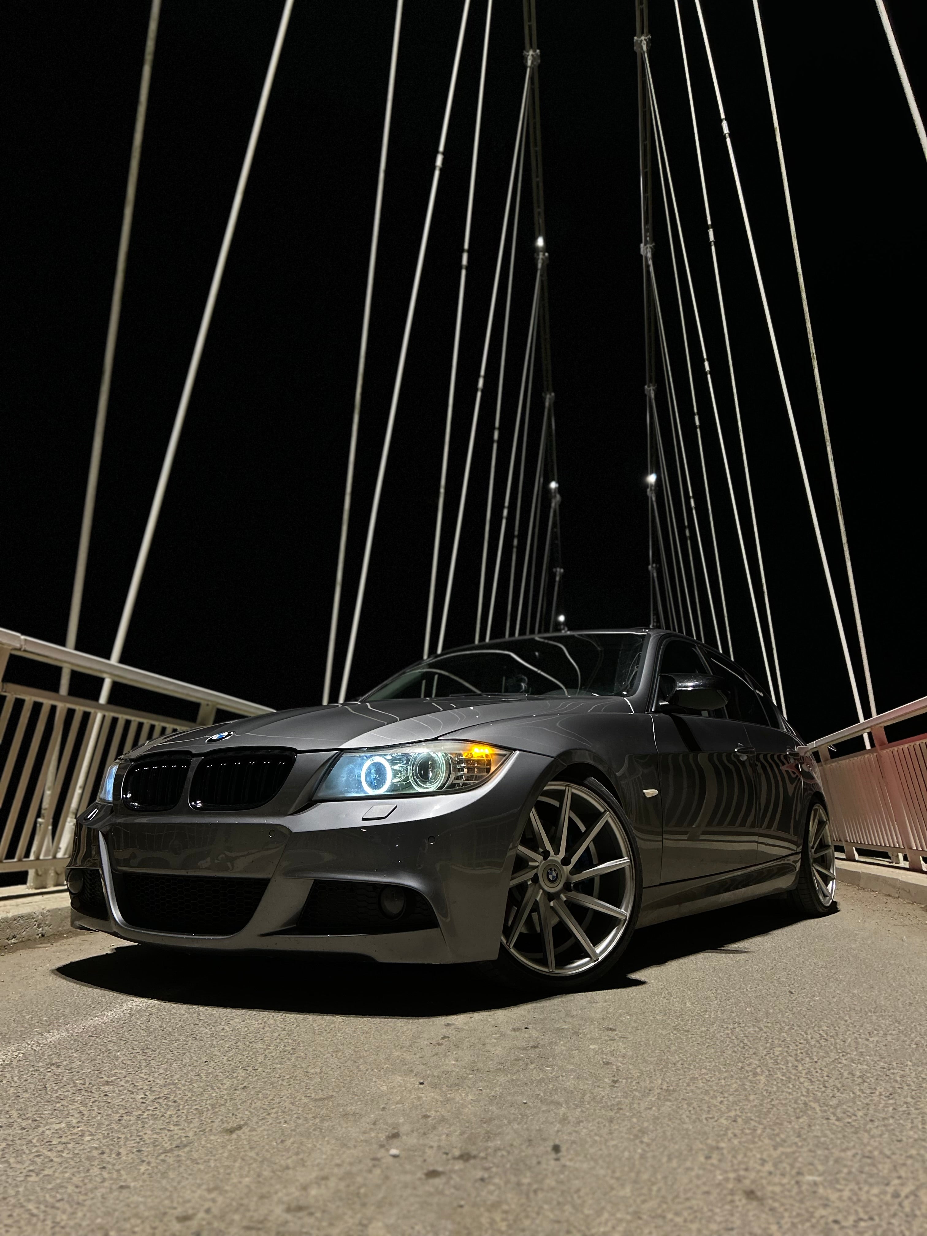 Grey BMW E90 car on a bridge at night